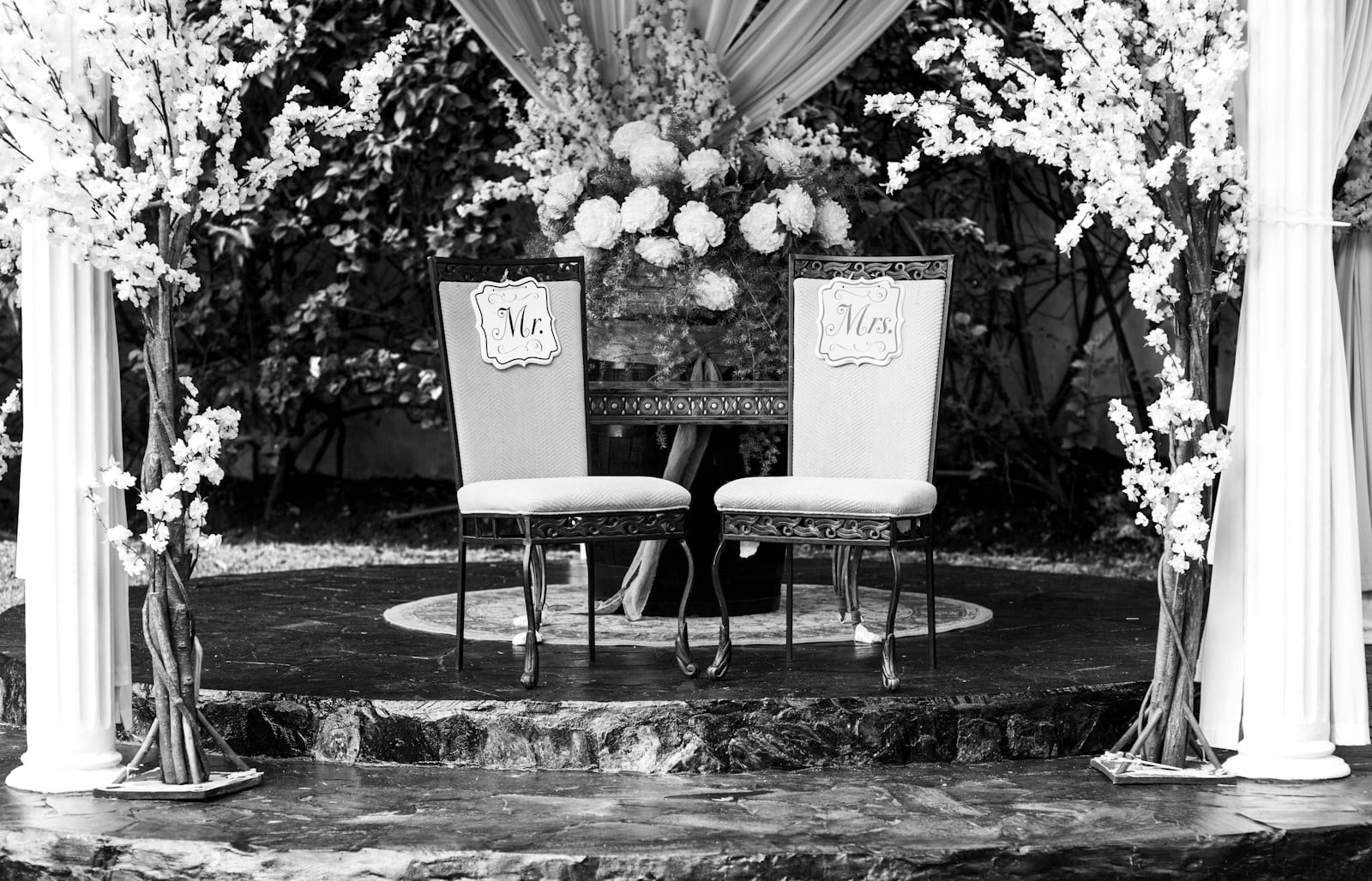 Sweetheart table with floral backdrop styled for a wedding